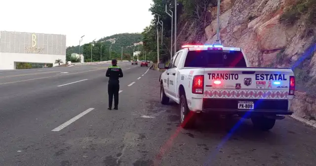 Agente de Tránsito Estatal en un mirador de la avenida Escénica de Acapulco orientando a un automovilista.