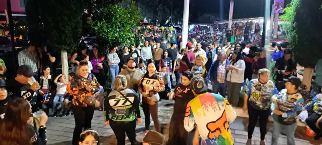 Personas disfrutando de música de banda en la plaza principal de Surutato