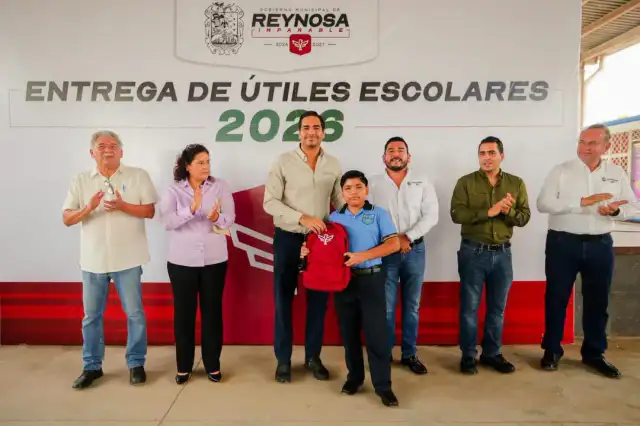 Estudiantes y autoridades durante la entrega de mochilas escolares en una primaria de Reynosa