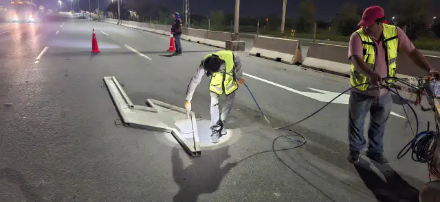 Trabajadores pintan flechas viales sobre el libramiento Monterrey-Matamoros en Reynosa