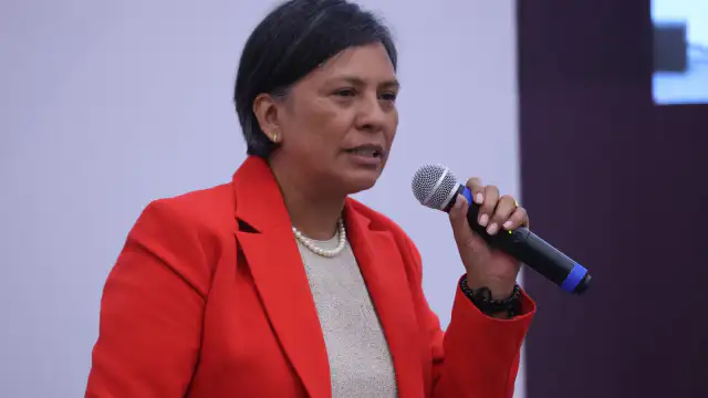 Personas en asamblea con banderas de México y logotipo del INE