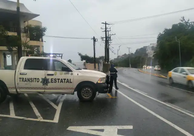 Vialidad de Acapulco con tránsito vehicular durante una lluvia