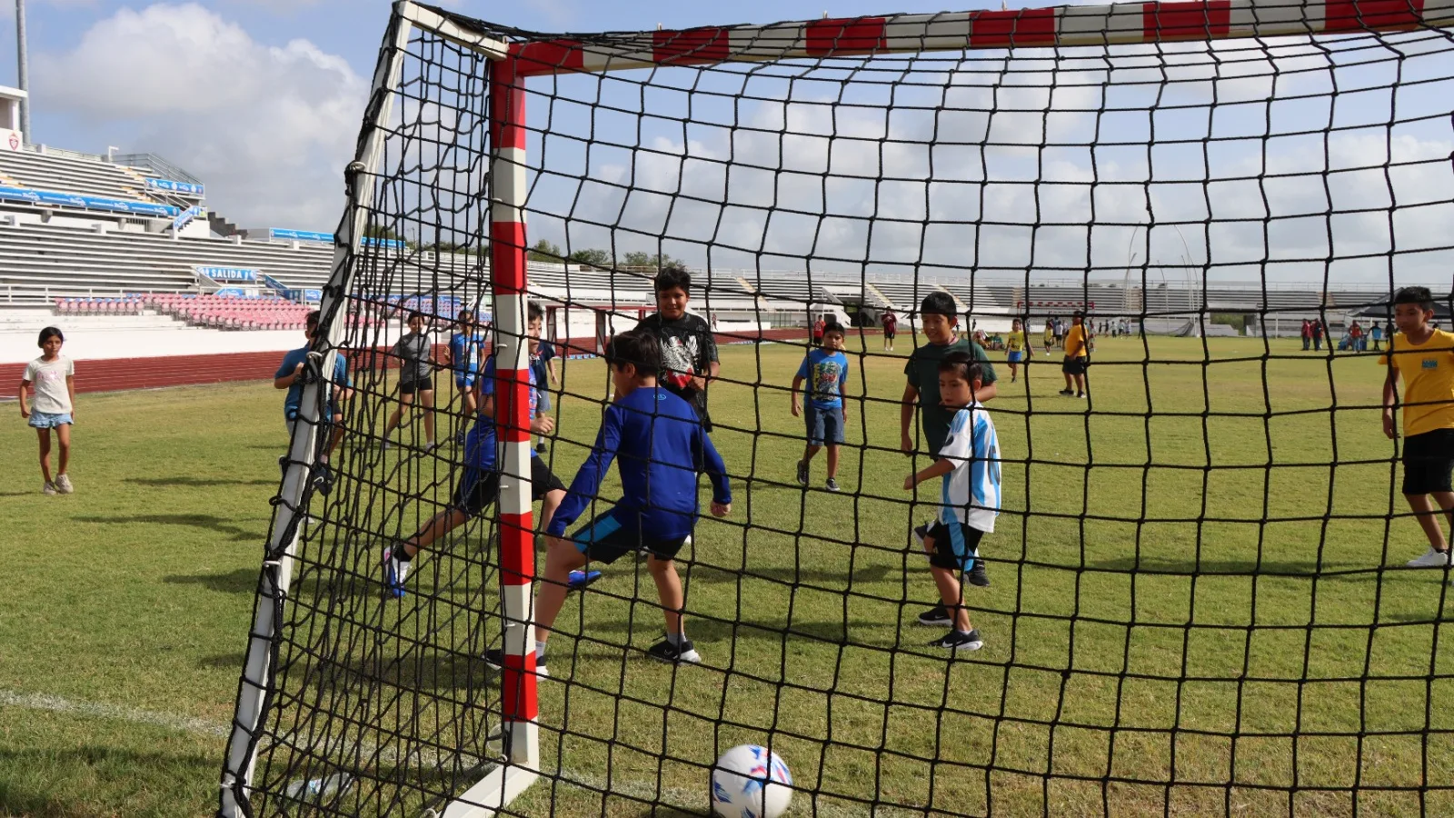 Niños jugando fútbol en el Polideportivo de Reynosa durante el campamento de verano